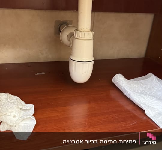צינור ניקוז מתחת לכיור עם מגבות נייר